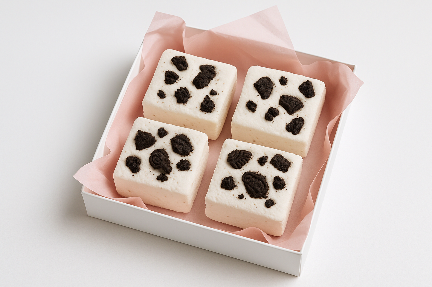 kan-du-g-ra-en-bild-p-4-mellan-stor-fyrkantigt-vit-mashmello-med-oreos-bitar-på i en vit gift box och med rosa gift papper under med-vit-background