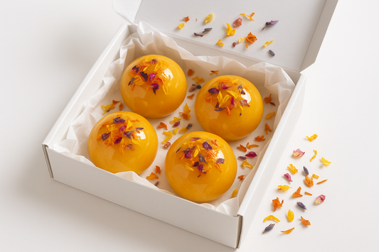 can-you-make-a-pic-of a White gift box with White gift papper and 4-sunrise-bloom-tea-bomb-in-a-glossy-glykos-bomb-with-some-dried-floder-on-and-white-background