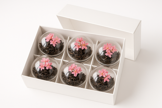 kan du göra en bild på en vit gift box med 6 genomskinliga te bomb som innehåller svart te och designade med rosa torkade blommor med vit bakgrund